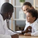 Doctor using stethoscope on child with mother watching.