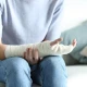 Person holding arm with a cast, related to fractures.