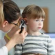Health professional examining child's ear for infection.